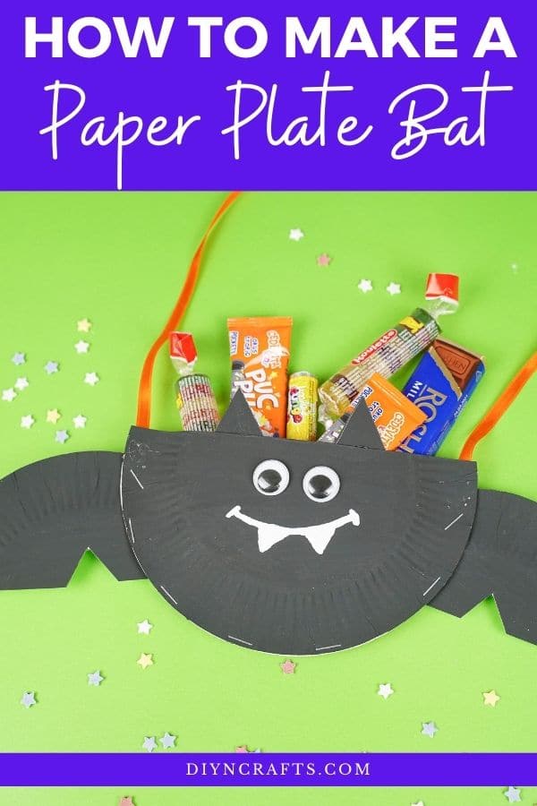 Paper plate bat on gree surface filled with candy