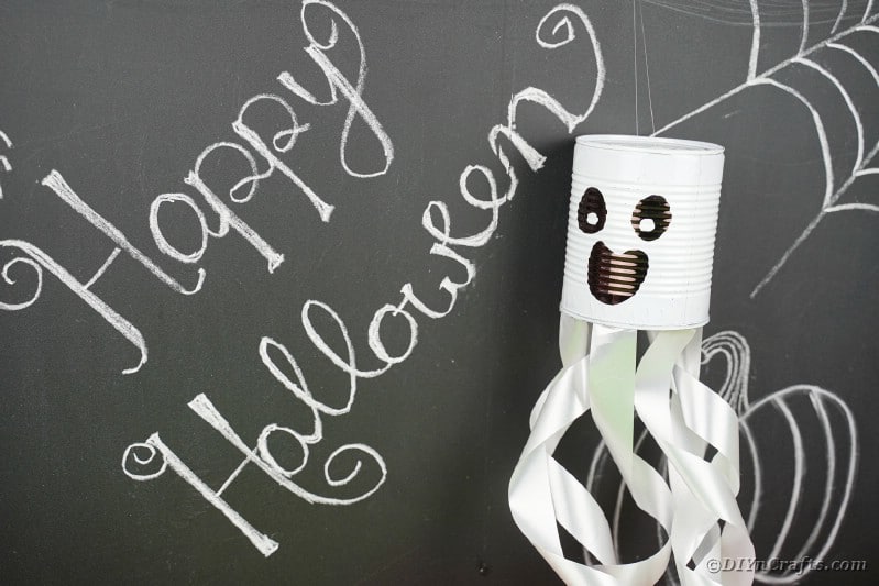 Tin can ghost by chalkboard wall