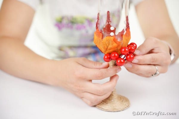 Gluing berries onto stemware