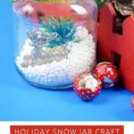 Homemade snow jar craft with a blue backdrop