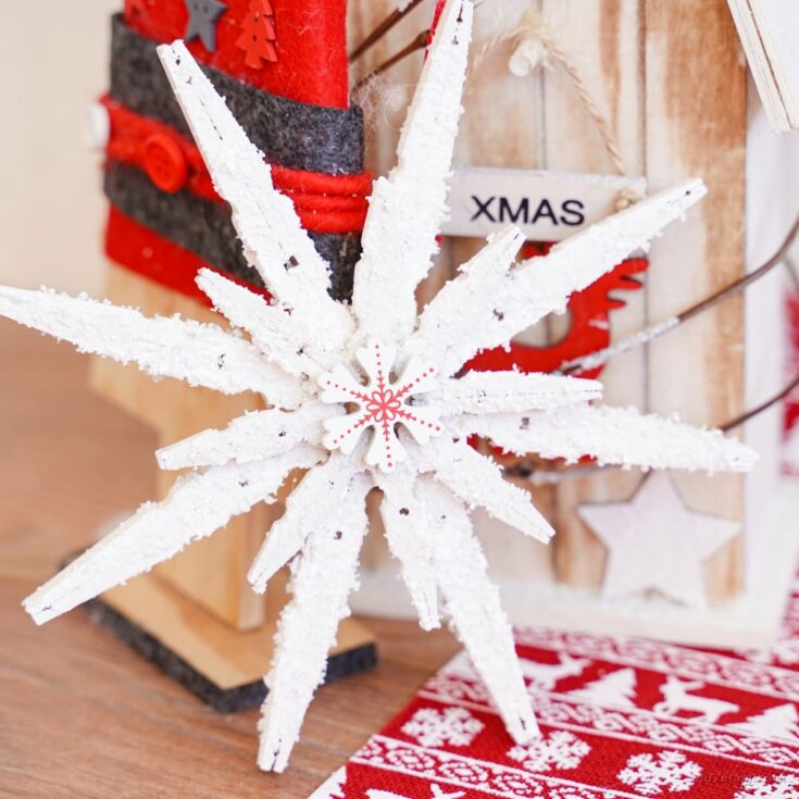 Clothespin snowflake in front of holiday decorations