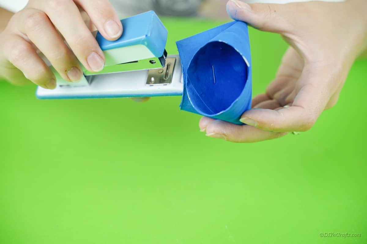stapled toilet paper roll with blue paint