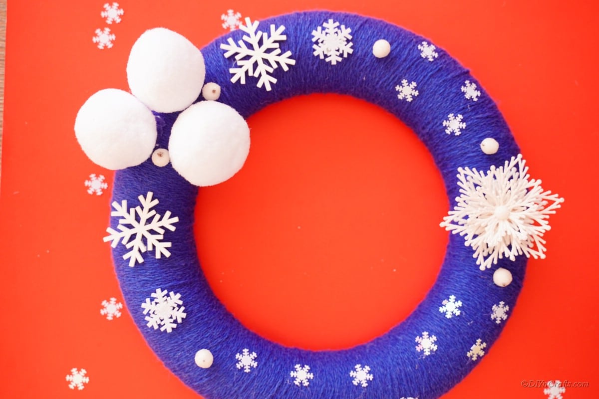 white and blue wreath with foam poms and snowflakes