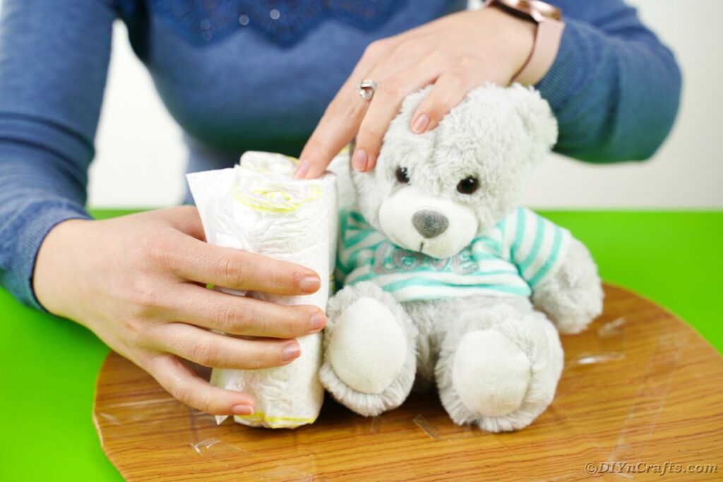 Placing diapers around teddy bear