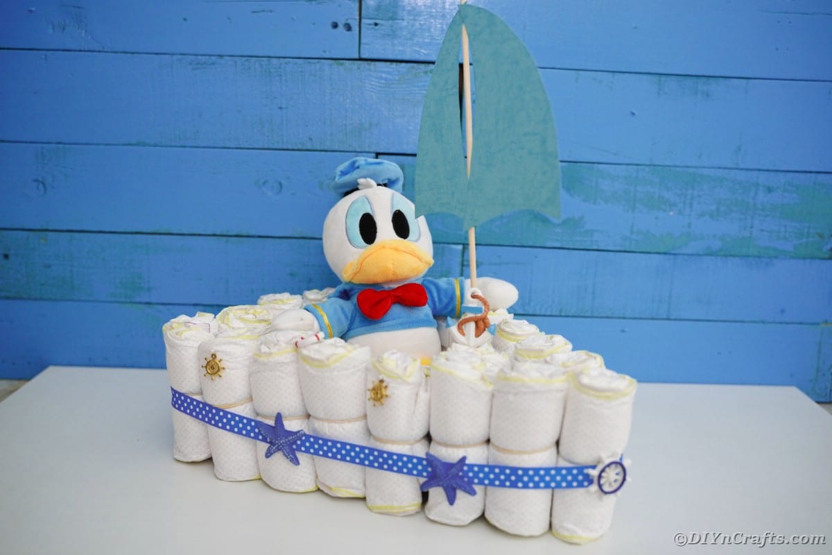 Diaper cake boat in front of blue boards