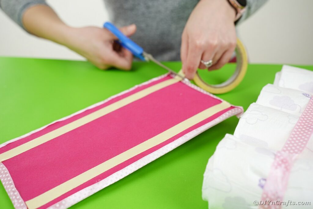 Adding tape to diaper roll