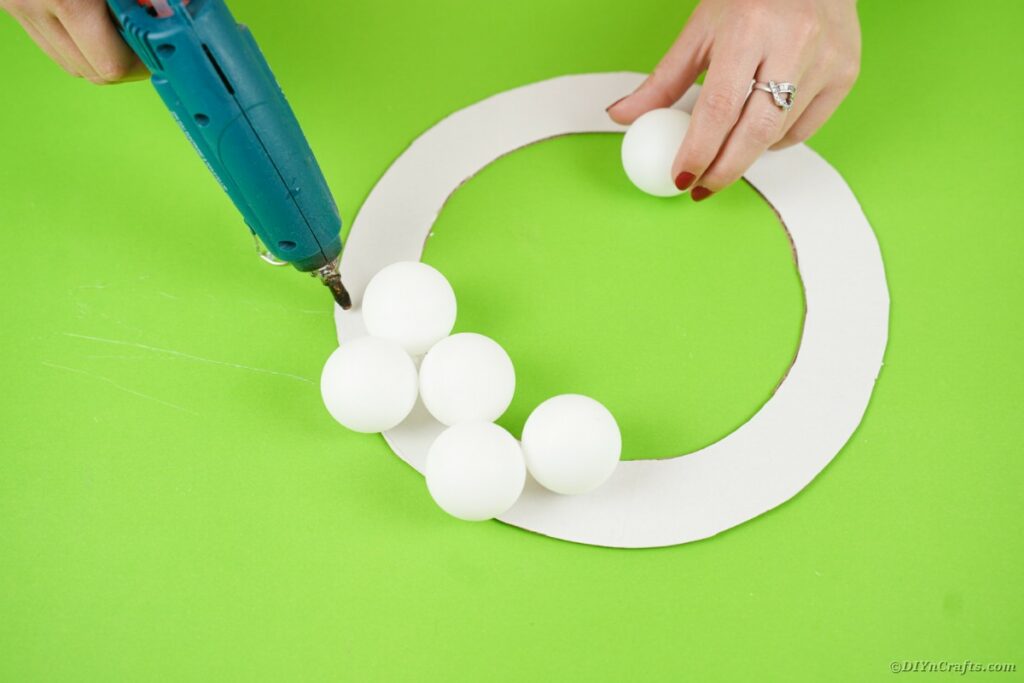 Gluing ping pong balls on wreath