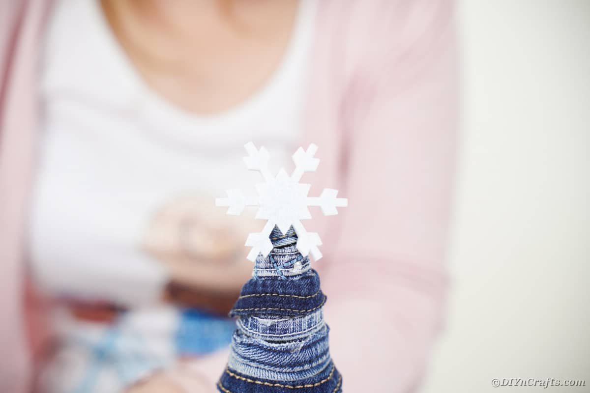 Gluing snowflake on denim tree