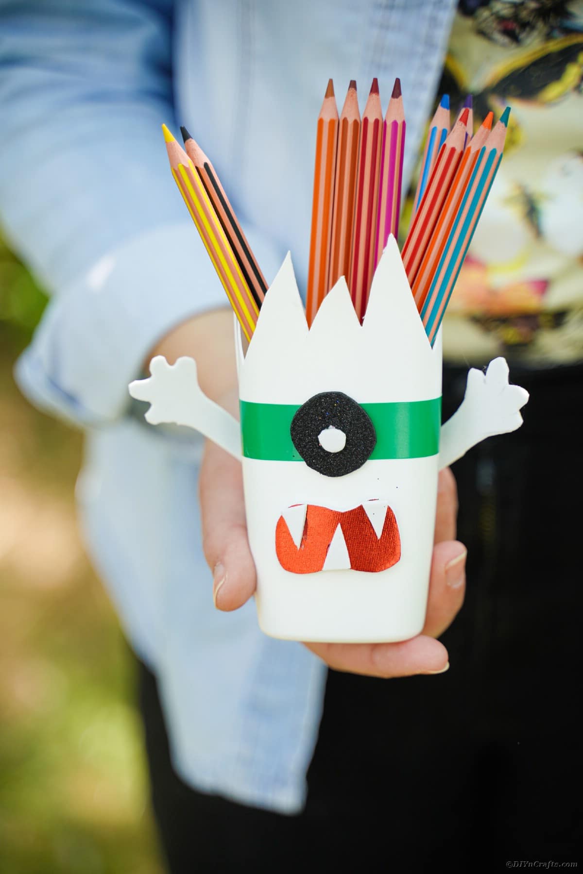 Woman holding monster pencil cans