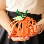Woman holding paper strip pumpkin