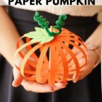 Woman holding paper strip pumpkin