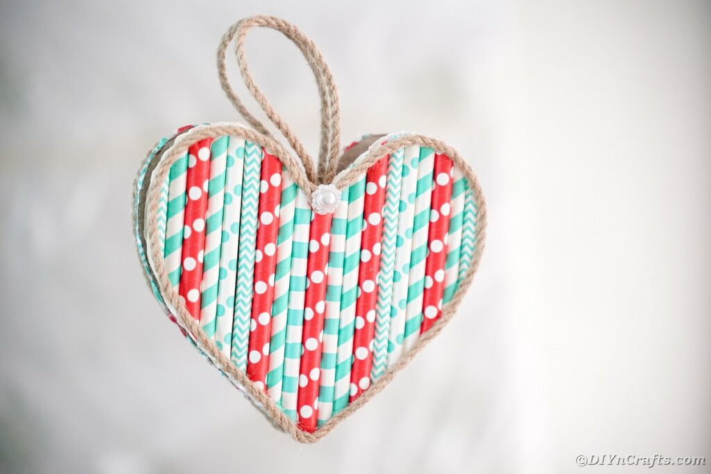 Paper straw heart on white wall