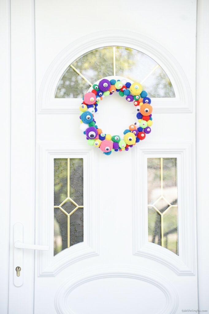 Colorful monster eye wreath on white front door