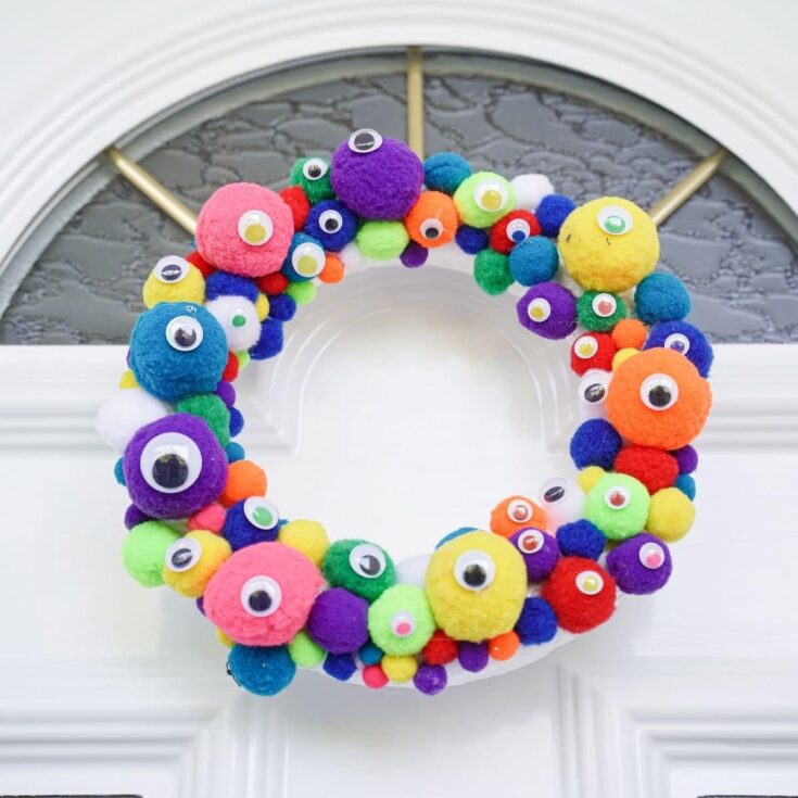 Colorful monster eye wreath on white front door