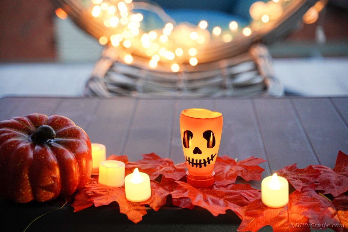 Pumpkin lantern on leaves with candles