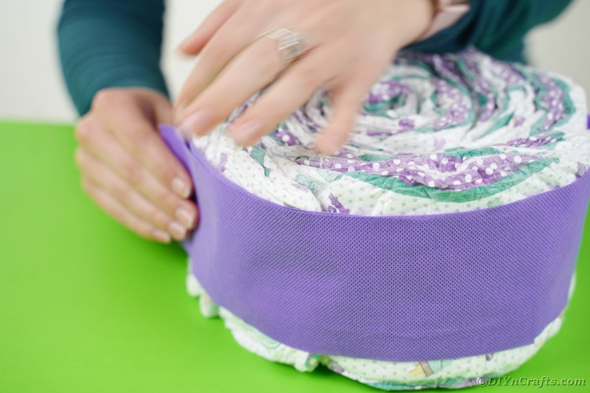 Gluing purple paper around diapers