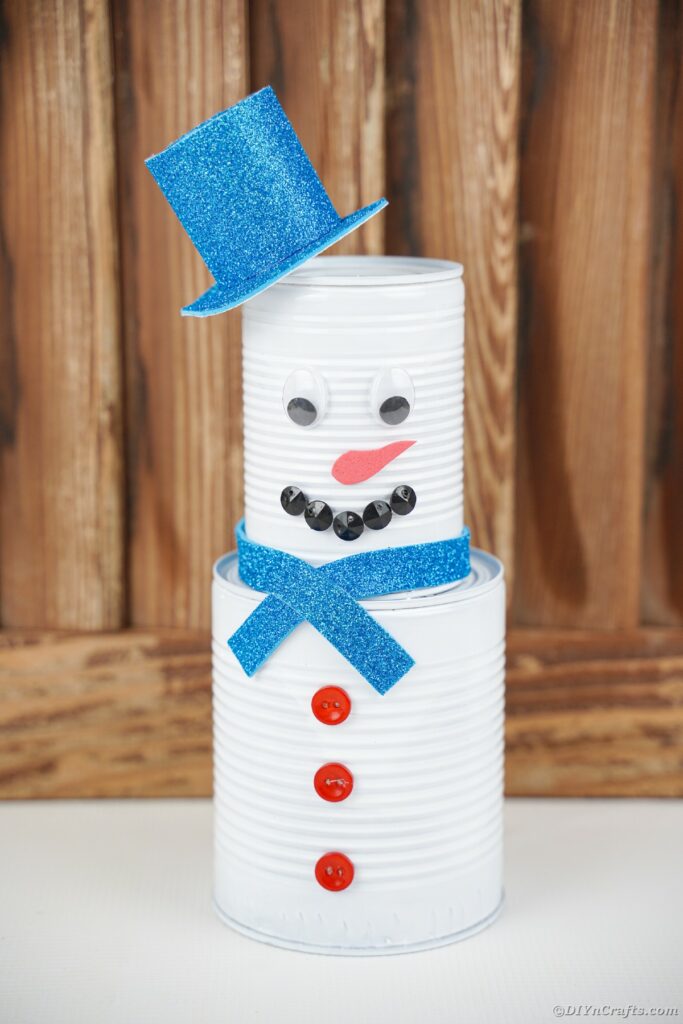 Tin can snowman by wooden wall