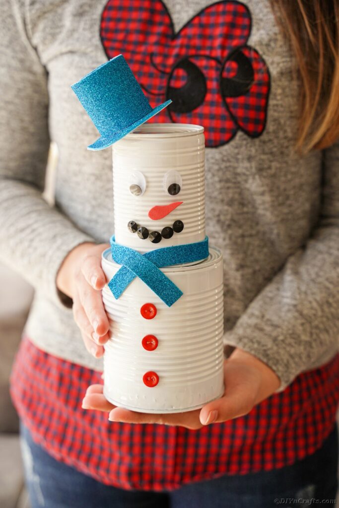 Woman holding tin can snowman