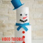 Tin can snowman against brick wall