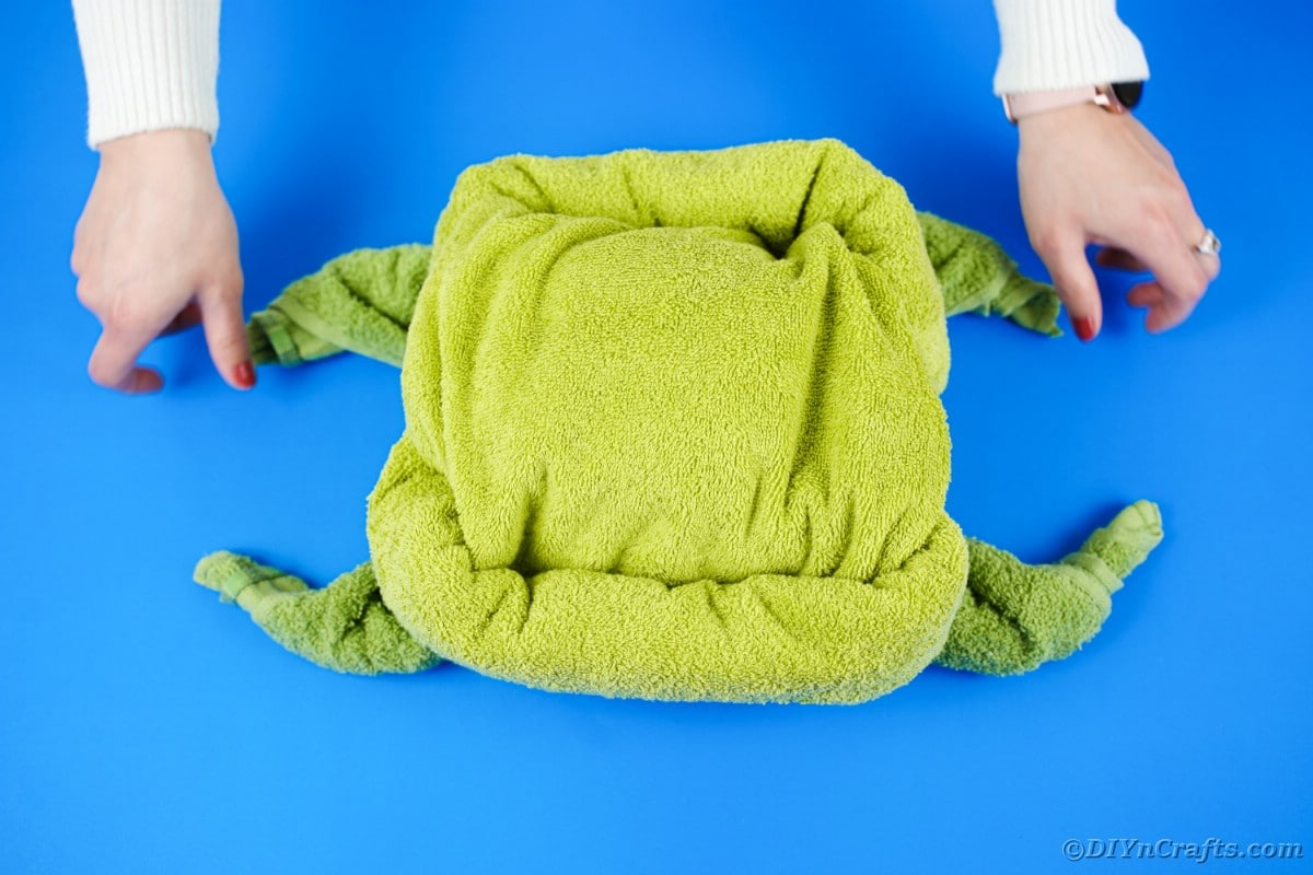 Stacking green towels on top of each other