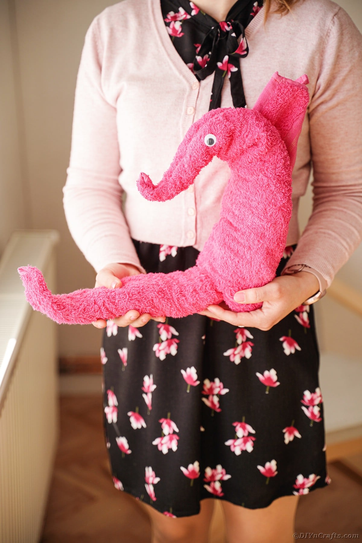 Woman holding pink seahorse towel
