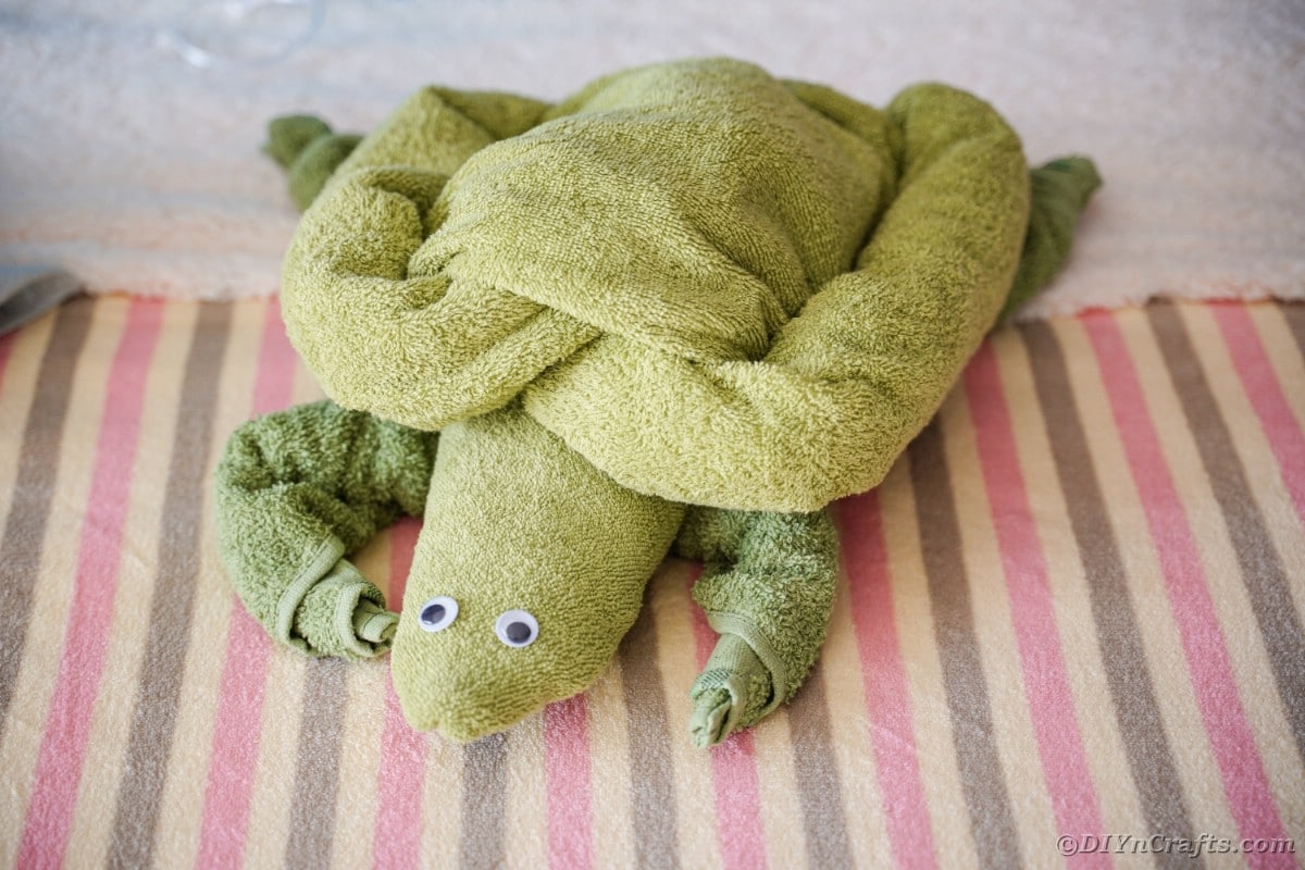 Green towel turtle on bed