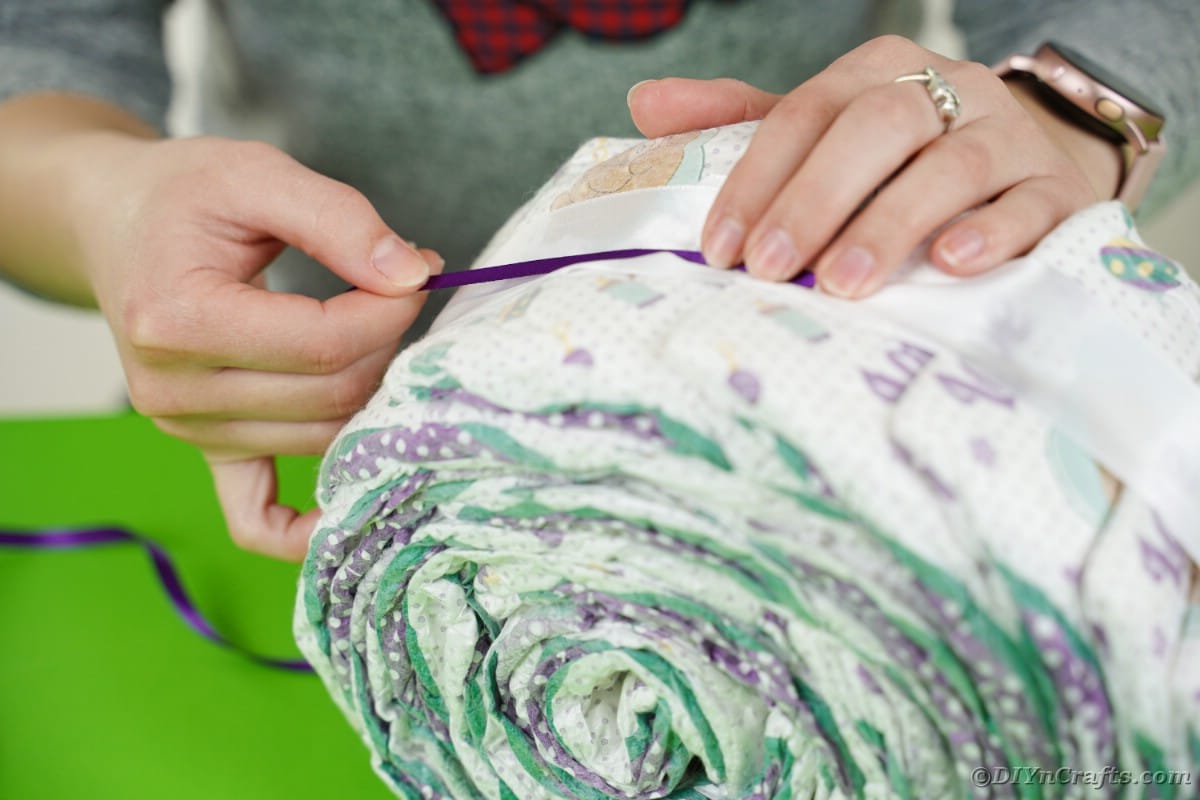 Adding purple ribbon to diaper roll