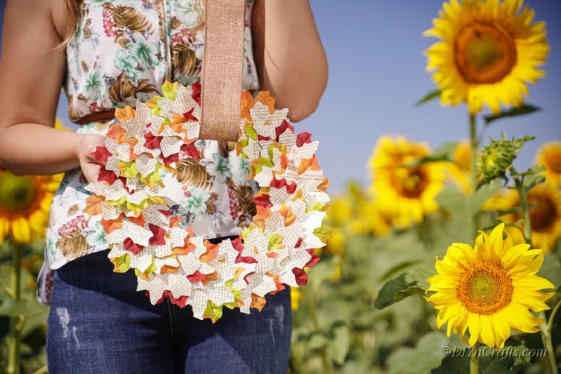 beautiful fall wreath woman holding in field 