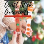 Craft stick Christmas ornaments being held