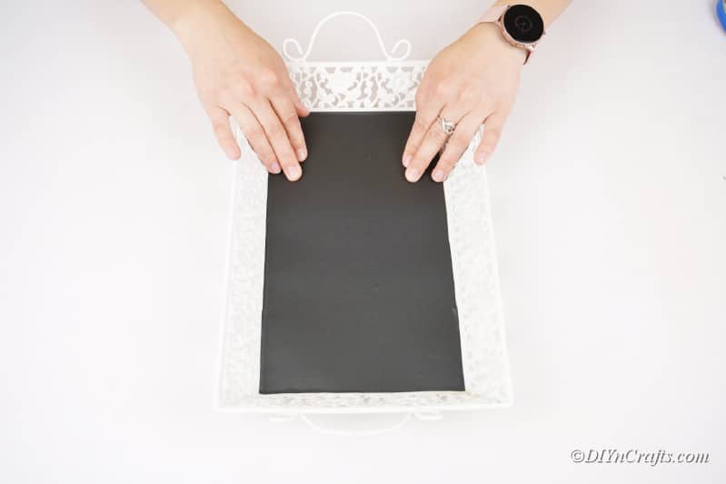 applying adhesive chalkboard sheet to tray