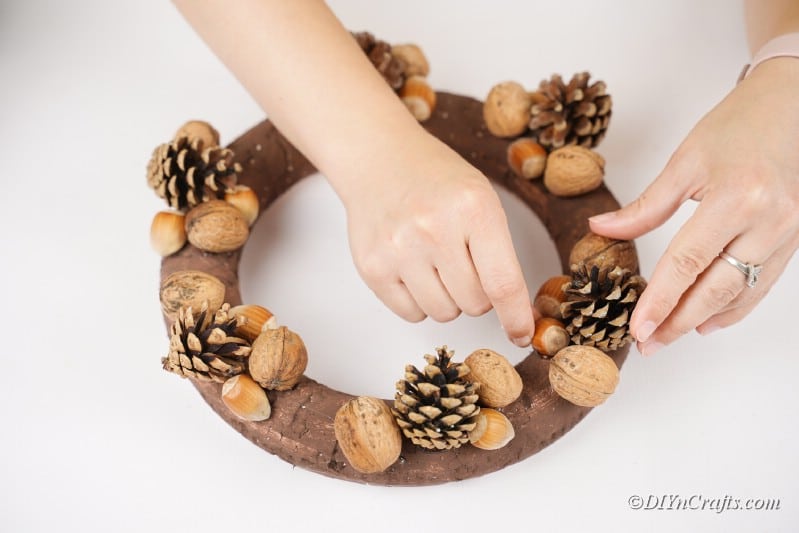 decorating a handmade wreath with natural elements