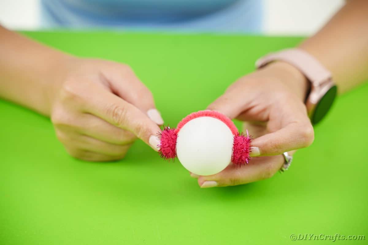 Adding pipe cleaner earmuff to ping pong ball