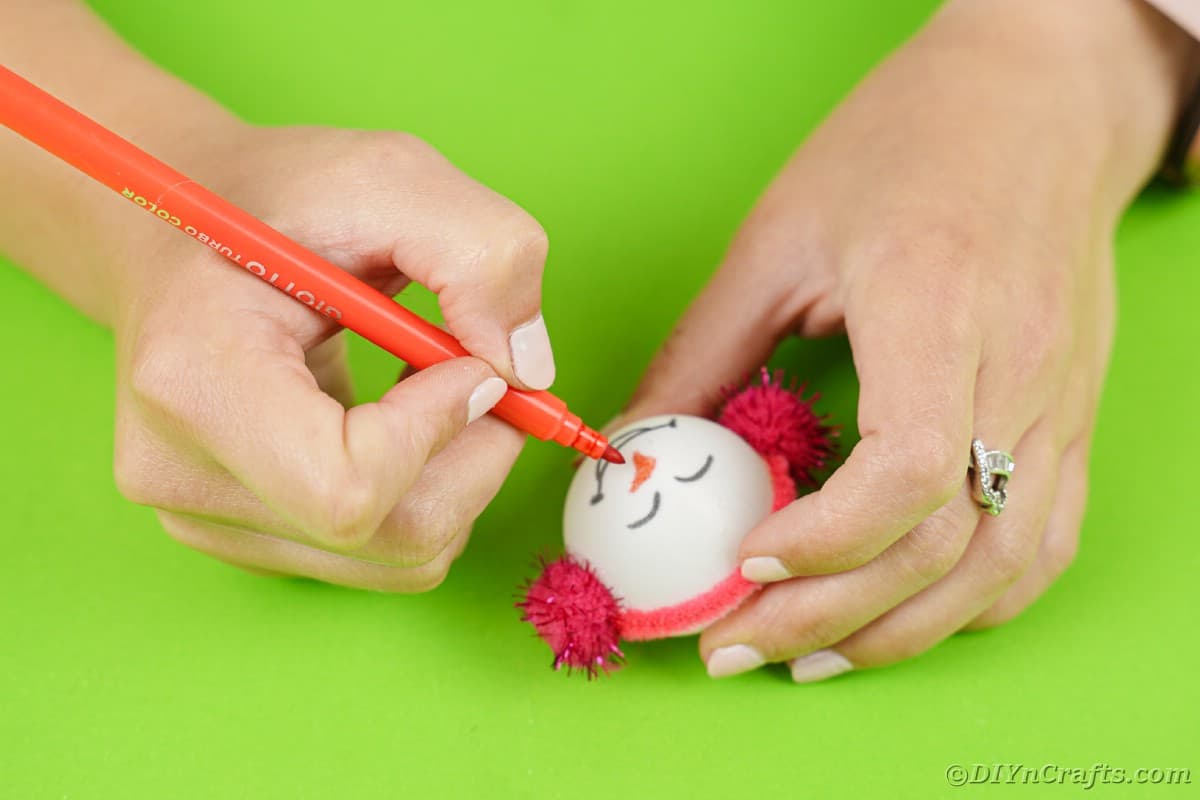 Drawing face on ping pong ball ornament