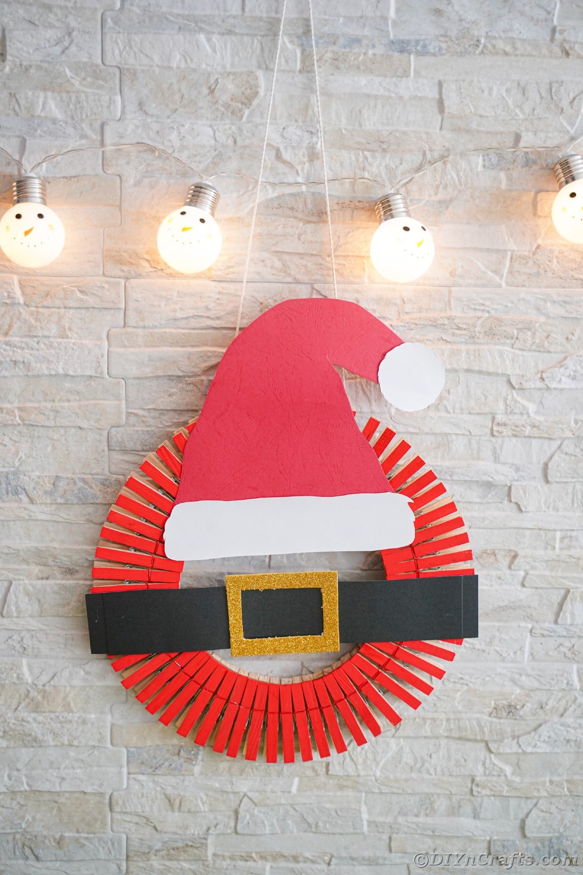 santa hat wreath hanging on white brick wall