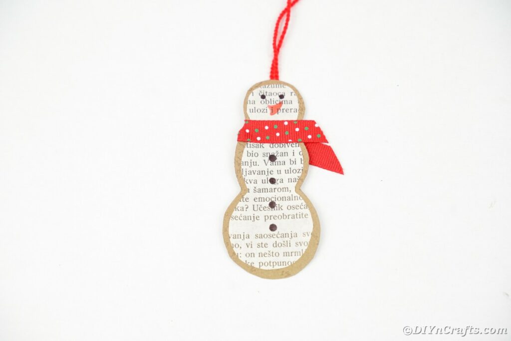Paper snowman ornament on white surface