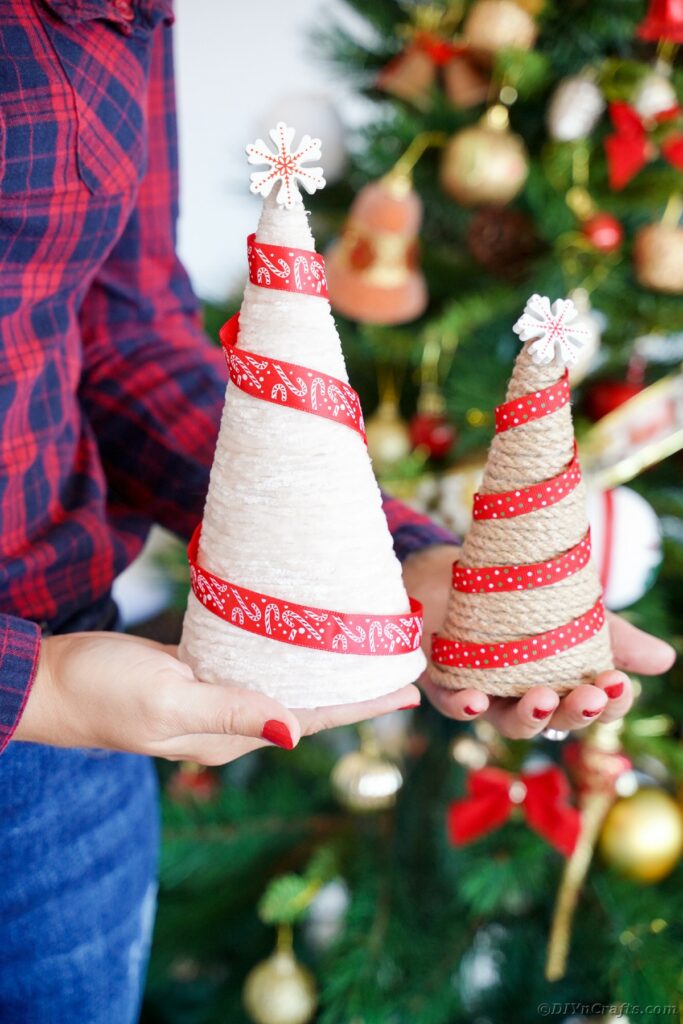 Woman holding twine wrapped trees