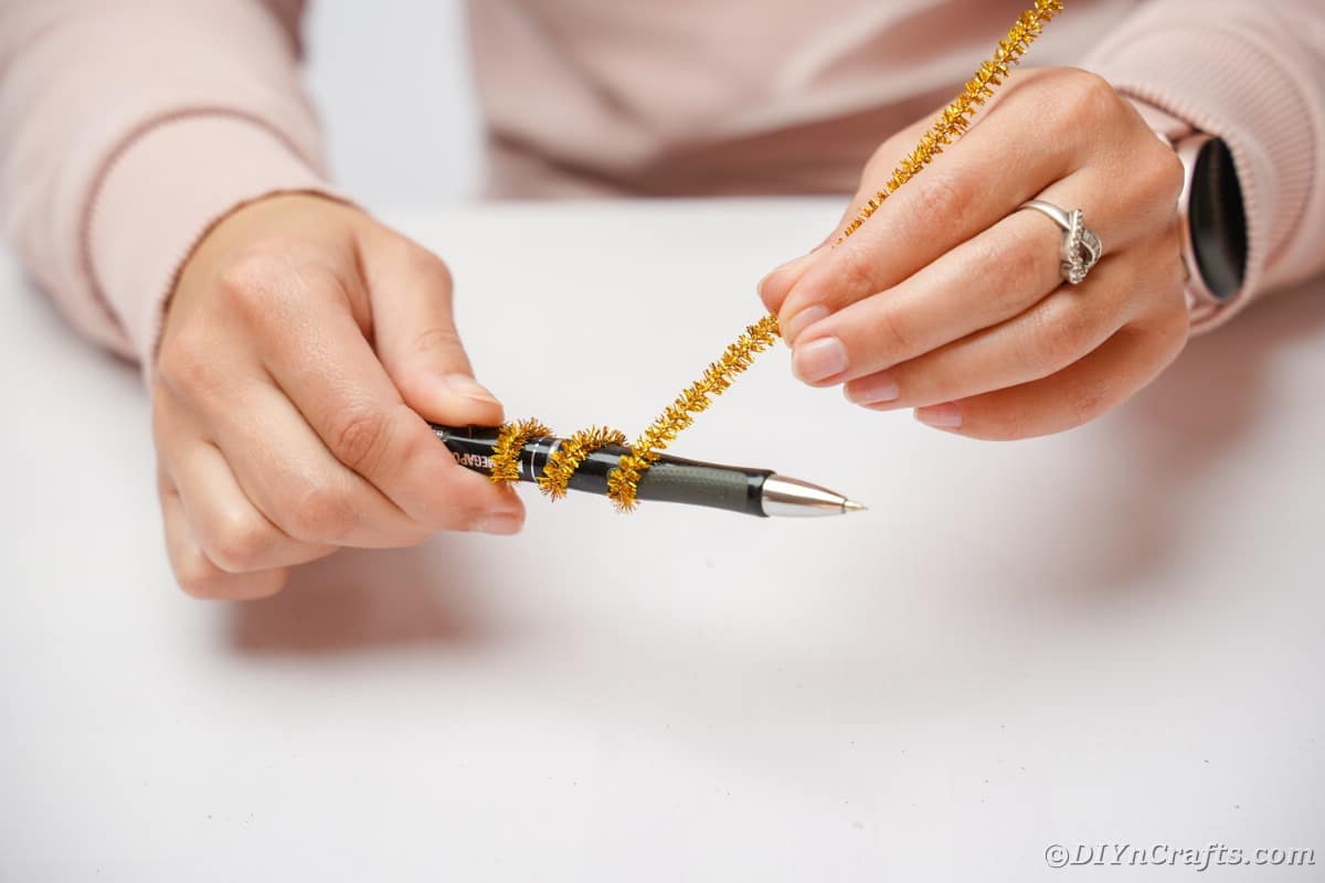 Gold pipe cleaner on pen