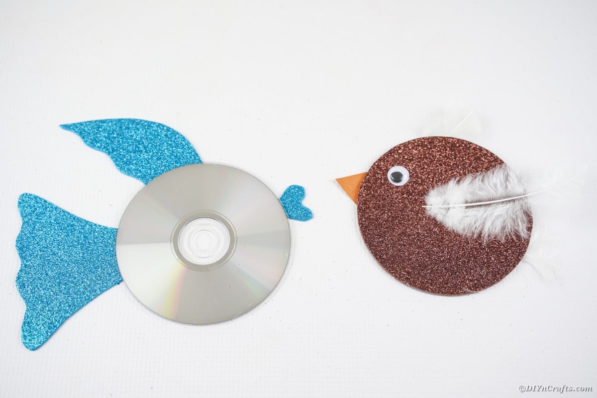 CD bird and CD fish on white table