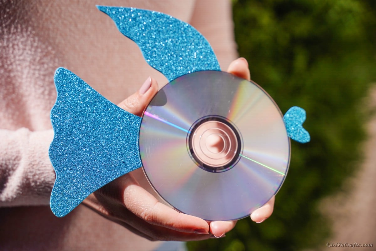 Woman holding blue CD fish