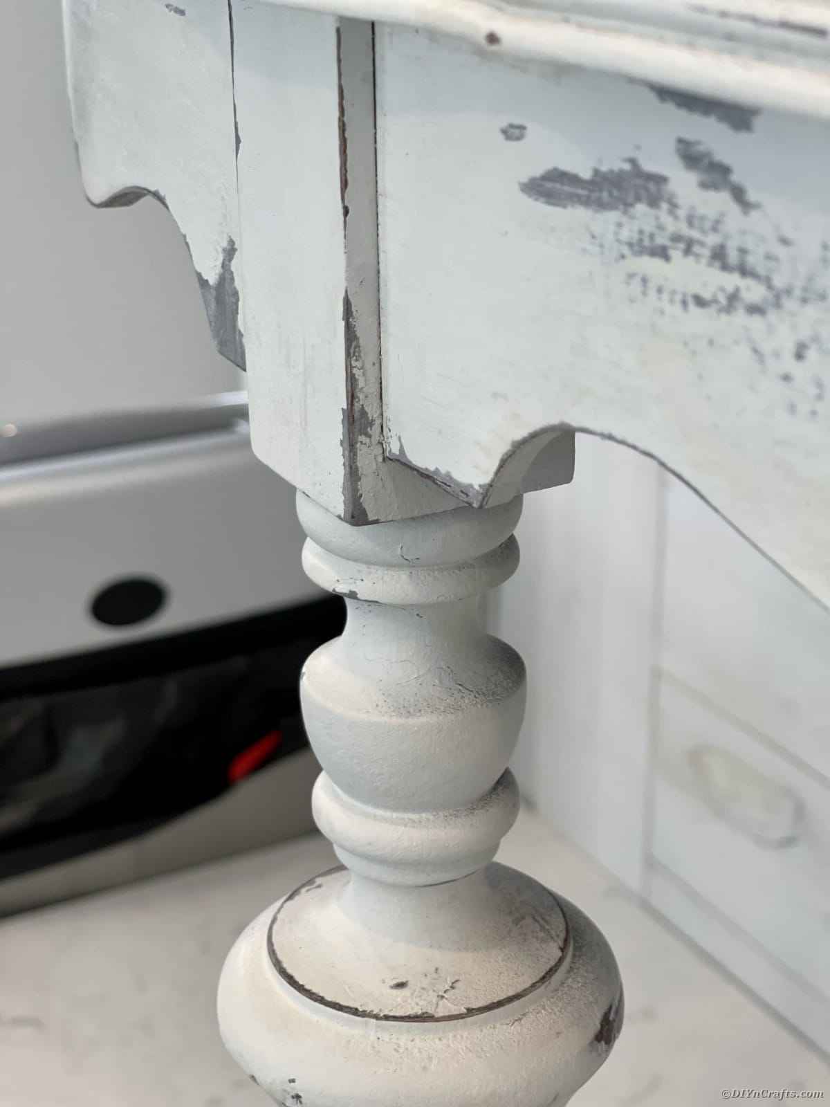 Corner of end table that has been weathered with white and gray