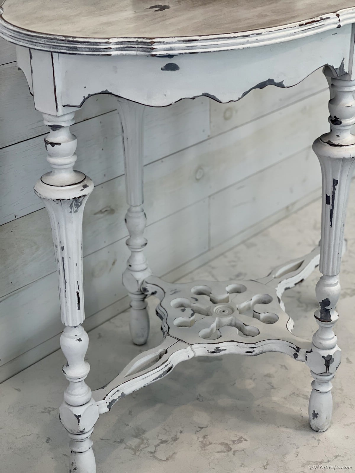 Base of weathered side table with white and gray distressing