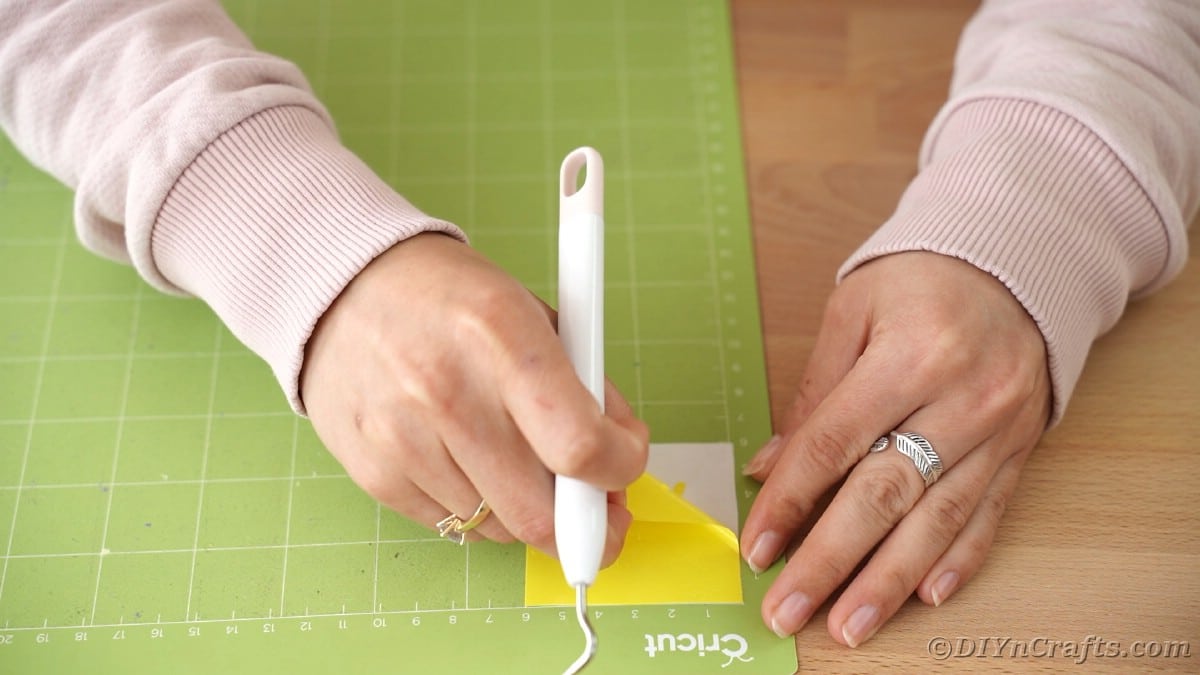 Peeling yellow vinyl off mat