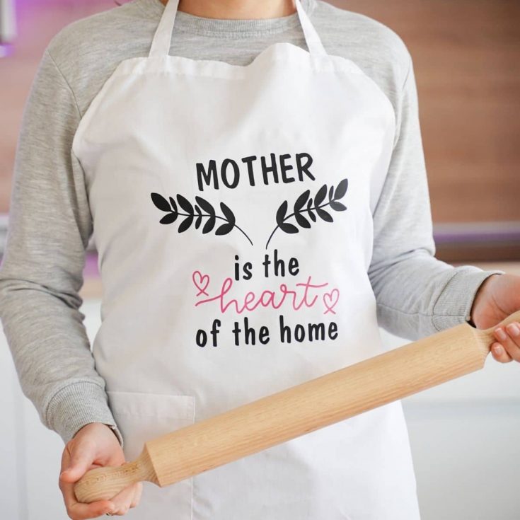 Woman in apron with black message holding rolling pin