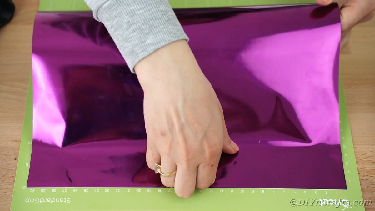 Placing purple foil adhesive onto green standard Cricut mat