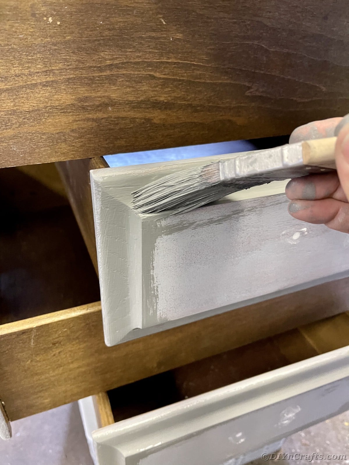 Painting a drawer with gray paint on brush