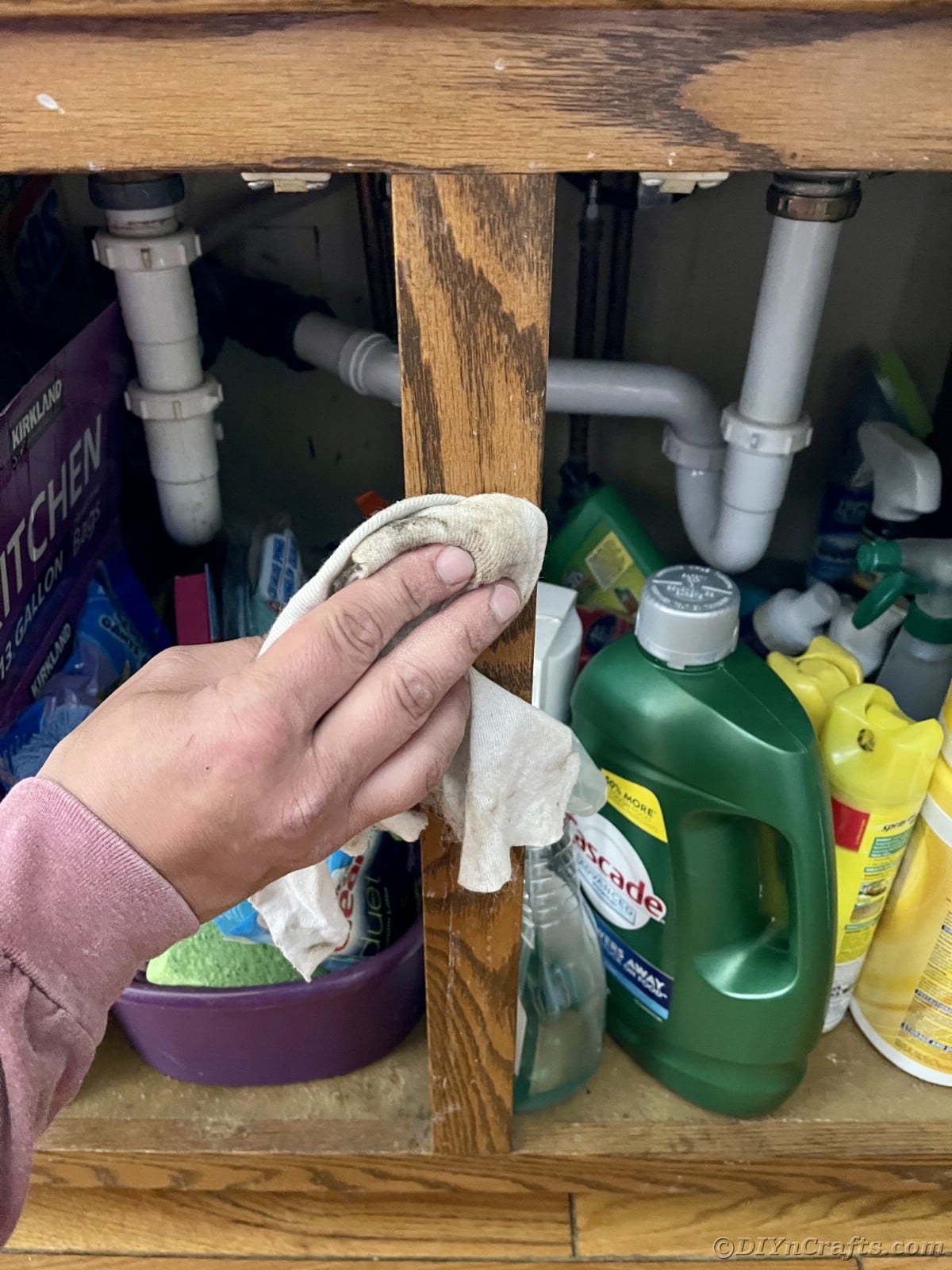 Wiping down cabinet under sink