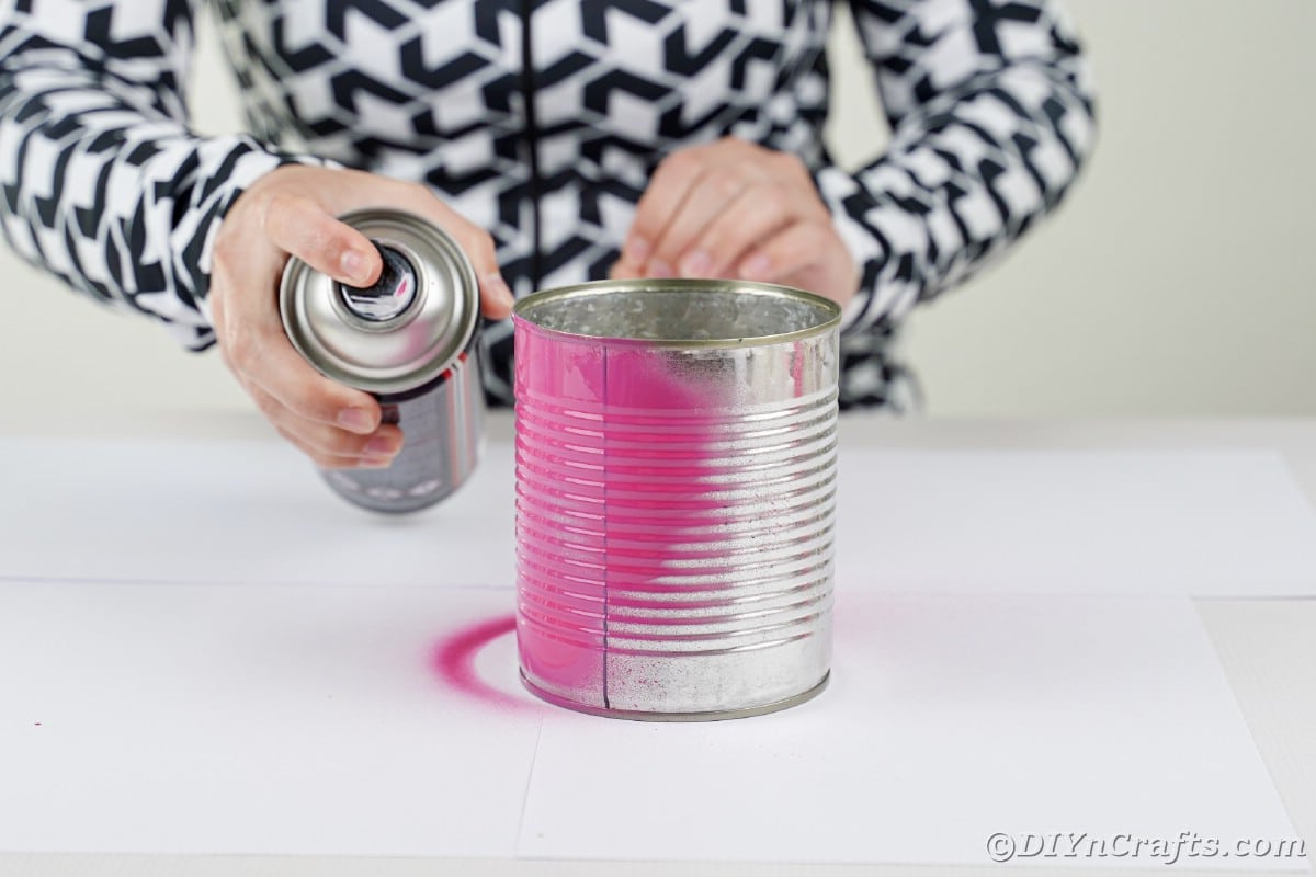 Spray painting a tin can pink