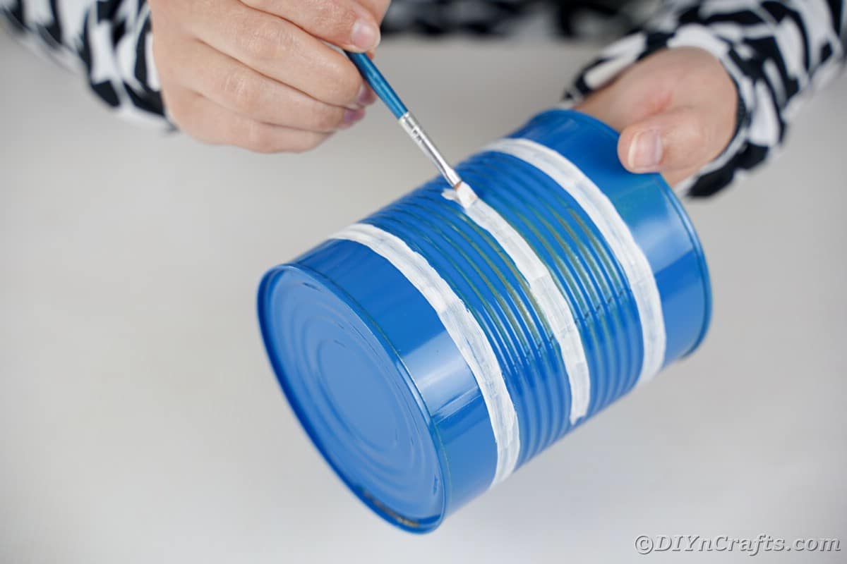 Painting white stripes on blue tin can