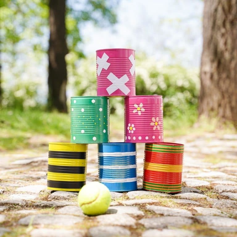 Six painted tin cans stacked together on stone