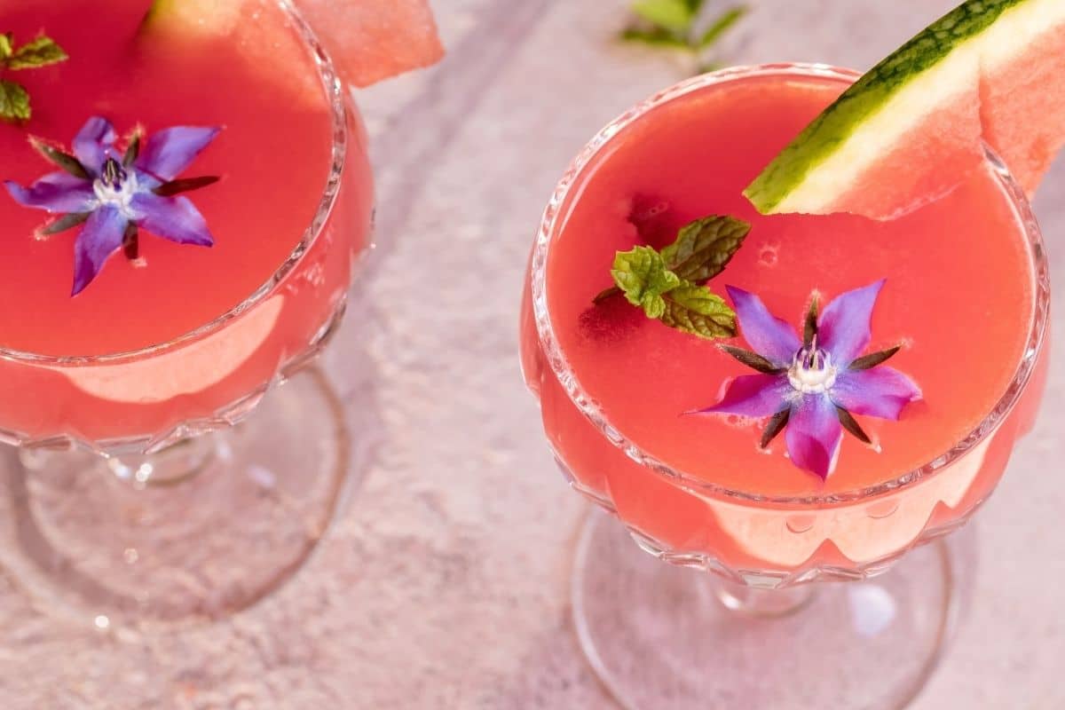 görögdinnye juice egy pohárban, borágó virágokkal díszítve
